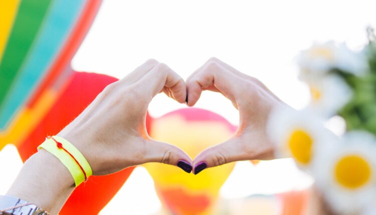 two people making a heart shape with their hands